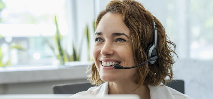 Smiling Customer Relations adviser wearing a phone headset